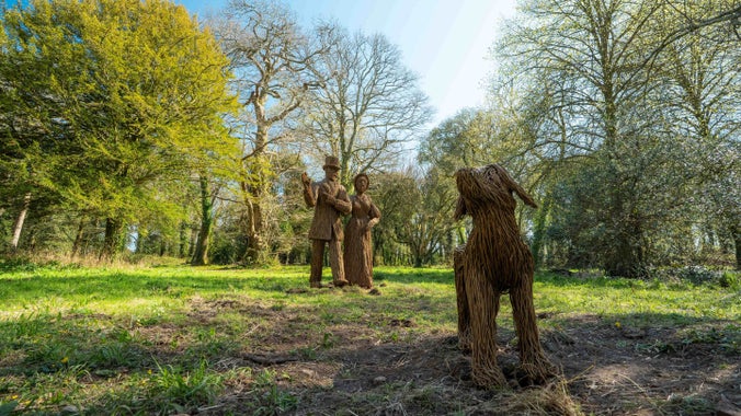 Willow sculptures of two people and a dog